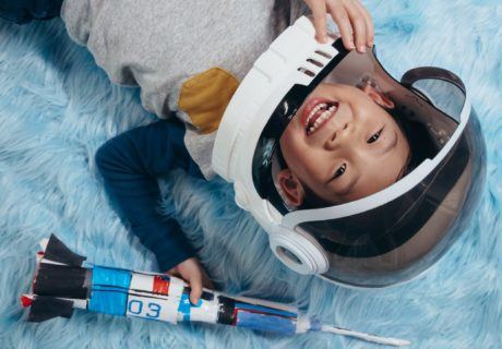 Elementary STEM Activity Happy Child in Space helmet holding a rocket