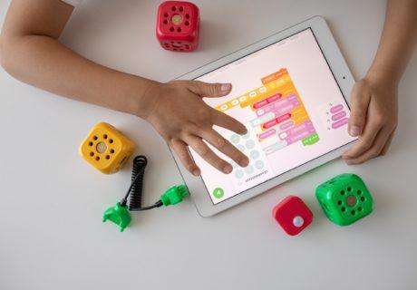 Best coding books for kids | Coderz childs arms on a tablet coding